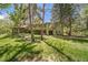 A large grassy backyard with a green two-story home in the background and patio area at 13955 W 26Th Ave, Golden, CO 80401