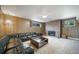 Retro basement featuring wood paneled walls, a brick fireplace, and vintage carpeting at 13955 W 26Th Ave, Golden, CO 80401