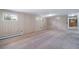 Open basement area with wood-paneled walls and neutral carpet; ideal for flexible living at 13955 W 26Th Ave, Golden, CO 80401