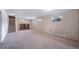 Large basement space with neutral carpet, wood paneled walls and access to stairs and other rooms at 13955 W 26Th Ave, Golden, CO 80401