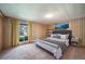 Cozy bedroom with wood-paneled walls, plush carpeting, and stylish decor accents and a queen bed at 13955 W 26Th Ave, Golden, CO 80401