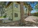 Green two-story home with large windows, a small patio and a tree in the front yard at 13955 W 26Th Ave, Golden, CO 80401