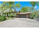 This property features an attached garage with brick accents and lush green landscaping at 13955 W 26Th Ave, Golden, CO 80401