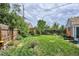 Large, well-maintained backyard featuring a spacious lawn, mature trees, a wooden fence and a lush garden at 9220 Lowell Blvd, Westminster, CO 80031