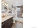 Elegant bathroom with dark wood vanity, granite countertop, and patterned tile floor at 9220 Lowell Blvd, Westminster, CO 80031