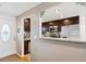 View of the entryway and kitchen with stainless steel appliances through a serving hatch at 9220 Lowell Blvd, Westminster, CO 80031