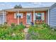 Charming brick home featuring a well-manicured front yard with vibrant flowerbeds and a welcoming porch at 9220 Lowell Blvd, Westminster, CO 80031