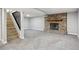 Spacious carpeted basement with a stone fireplace and staircase at 19644 E Girard Dr, Aurora, CO 80013