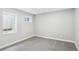 Empty bedroom featuring neutral walls and carpets, with two windows providing natural light at 19644 E Girard Dr, Aurora, CO 80013