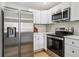 Well-lit kitchen featuring stainless steel appliances, white cabinets, and light countertops at 19644 E Girard Dr, Aurora, CO 80013