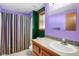 Vibrant bathroom featuring a unique color scheme, vanity and shower with patterned curtain at 3619 Estates Cir, Larkspur, CO 80118