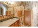 Unique bathroom featuring wood cabinets and quirky wallpaper at 3619 Estates Cir, Larkspur, CO 80118