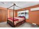 Bedroom featuring a cozy canopy bed, carpeted floors, two windows, and a door at 3619 Estates Cir, Larkspur, CO 80118
