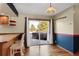 Bright dining area with wood floors, stylish lighting, and sliding glass doors opening to a deck with a hot tub at 3619 Estates Cir, Larkspur, CO 80118