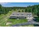 Expansive home with a large wraparound porch, manicured lawn, and an attached two-car garage at 3619 Estates Cir, Larkspur, CO 80118