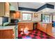 Well-lit kitchen featuring wood cabinetry, checkerboard floors, and vintage-style appliances at 3619 Estates Cir, Larkspur, CO 80118