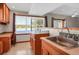 Bright kitchenette featuring a built-in desk, stainless steel sink and cabinets with ample storage at 3619 Estates Cir, Larkspur, CO 80118