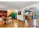 Spacious living area with wood floors and a stone archway to the kitchen and staircase at 3619 Estates Cir, Larkspur, CO 80118