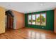 An empty living room showcasing hardwood floors, great lighting, and a window with an exterior view at 3619 Estates Cir, Larkspur, CO 80118