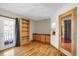 Living room featuring light hardwood floors, a built in bookshelf, and a glass panel door to the exterior at 3619 Estates Cir, Larkspur, CO 80118
