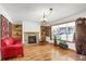 Cozy living room with a stone fireplace, hardwood floors, built-in shelving and natural light at 3619 Estates Cir, Larkspur, CO 80118