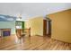 Bright room featuring hardwood floors, an old fireplace, and a yellow accent wall with a stair case at 3619 Estates Cir, Larkspur, CO 80118