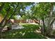 Lush backyard featuring a stone patio, a wooden fence, and mature trees that provide ample shade at 710 Raleigh St, Denver, CO 80204