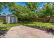 Large backyard featuring a storage shed, a lush lawn, garden beds, and mature trees at 710 Raleigh St, Denver, CO 80204