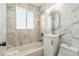 Bathroom features marble tile, modern vanity, shower and tub combo with a frosted glass window at 710 Raleigh St, Denver, CO 80204
