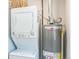 A utility room featuring stacked washer and dryer next to a Rheem Performance water heater at 710 Raleigh St, Denver, CO 80204