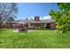 Expansive backyard with a well-maintained lawn, patio, and outdoor seating area at 4031 S Hudson Way, Cherry Hills Village, CO 80113