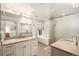 Bright bathroom featuring double sinks, walk-in shower, and soaking tub at 4031 S Hudson Way, Cherry Hills Village, CO 80113