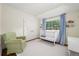 Cozy Bedroom with a white crib, green chair, and natural light at 4031 S Hudson Way, Cherry Hills Village, CO 80113