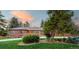 Beautiful single-story brick home at dusk with lush landscaping and a well-manicured front lawn at 4031 S Hudson Way, Cherry Hills Village, CO 80113