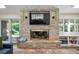 Living room showcasing a stacked stone fireplace with mounted TV and built-in shelves at 4031 S Hudson Way, Cherry Hills Village, CO 80113
