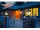Charming brick home featuring an illuminated front entrance and decorative iron gate, warmly lit at dusk at 4031 S Hudson Way, Cherry Hills Village, CO 80113