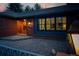 Welcoming brick home with a decorative wood front door and sidelight window at dusk, showing a brick walkway at 4031 S Hudson Way, Cherry Hills Village, CO 80113