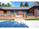 Welcoming brick porch with iron railings and manicured flower beds at 4031 S Hudson Way, Cherry Hills Village, CO 80113