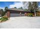 Spacious three-car garage with a paved driveway and mature landscaping at 4031 S Hudson Way, Cherry Hills Village, CO 80113
