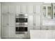 Modern kitchen featuring stainless steel double ovens and ample gray cabinet storage space at 4031 S Hudson Way, Cherry Hills Village, CO 80113