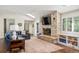 Inviting living room with stone fireplace, built-in shelving, and ample natural light at 4031 S Hudson Way, Cherry Hills Village, CO 80113