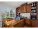 Home office featuring wood built-in bookshelves, a large desk, and shuttered windows at 4031 S Hudson Way, Cherry Hills Village, CO 80113