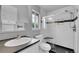 Modern bathroom features a glass-enclosed tiled shower, sleek black countertops, and a stylish vanity with ample lighting at 12651 Elm St, Thornton, CO 80241