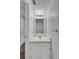 White bathroom with vanity, sink, and mirror is brightly lit at 12651 Elm St, Thornton, CO 80241
