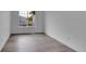 Bright, minimalist bedroom with hardwood floors, a large window, white trim and walls, and a neutral color palette at 12651 Elm St, Thornton, CO 80241