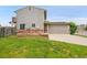 Rear exterior of home with brick accents and solar panels on garage at 12651 Elm St, Thornton, CO 80241