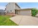 Home's gray exterior, highlighting a two-car garage and driveway at 12651 Elm St, Thornton, CO 80241