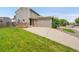 Home exterior featuring a two-car garage, brick accents, and lush green lawn at 12651 Elm St, Thornton, CO 80241