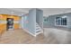 Open-concept living room with light-colored hardwood flooring, lots of natural light, and entry to upper level at 12651 Elm St, Thornton, CO 80241
