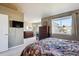 Bright bedroom with a large window, dresser, and television provides a comfortable and stylish retreat at 4175 S Andes St, Aurora, CO 80013